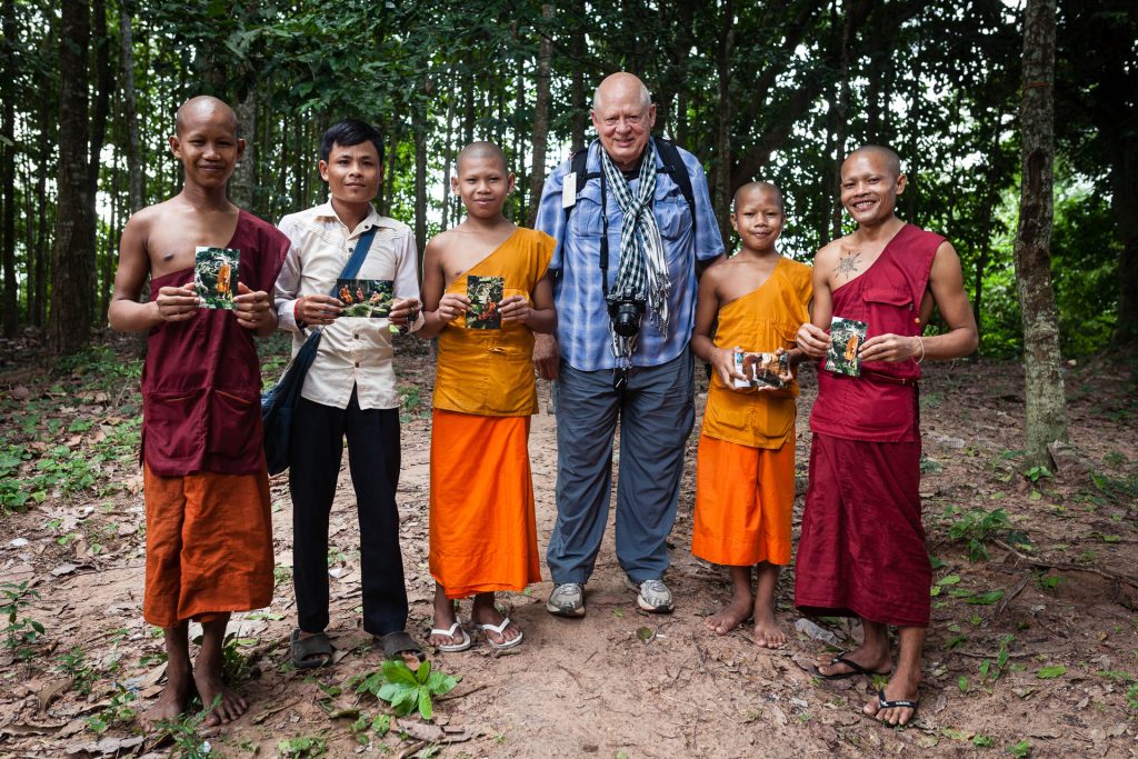 Greg offrant des photos à des moines rencontrés lors d'un premier voyage photo en 2015